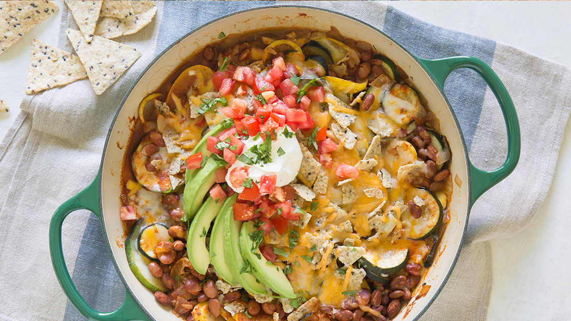 Green dutch oven filled with a taco bean bake.