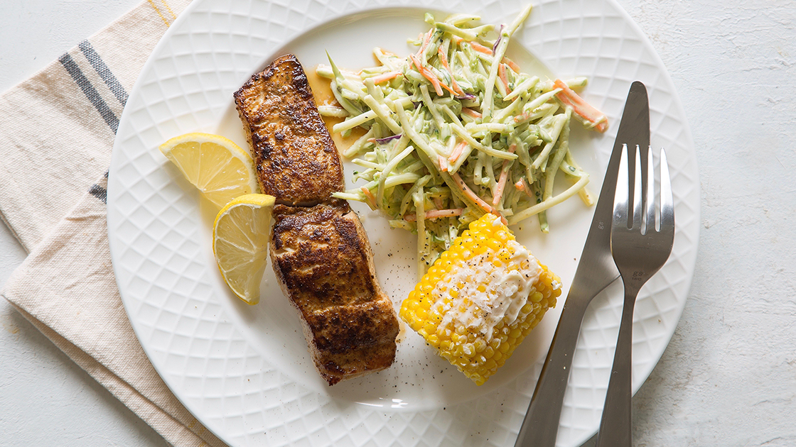 Blackened Mahi fillet with corn on the cob, slaw and lemon wedges.