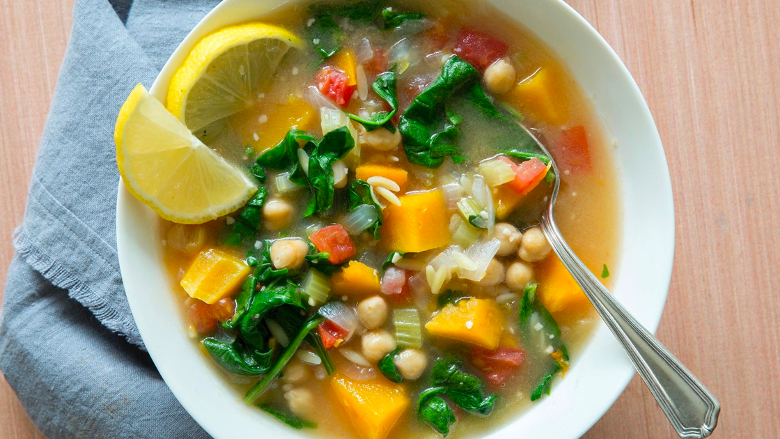 A bowl of stew with butternut squash and spinach.