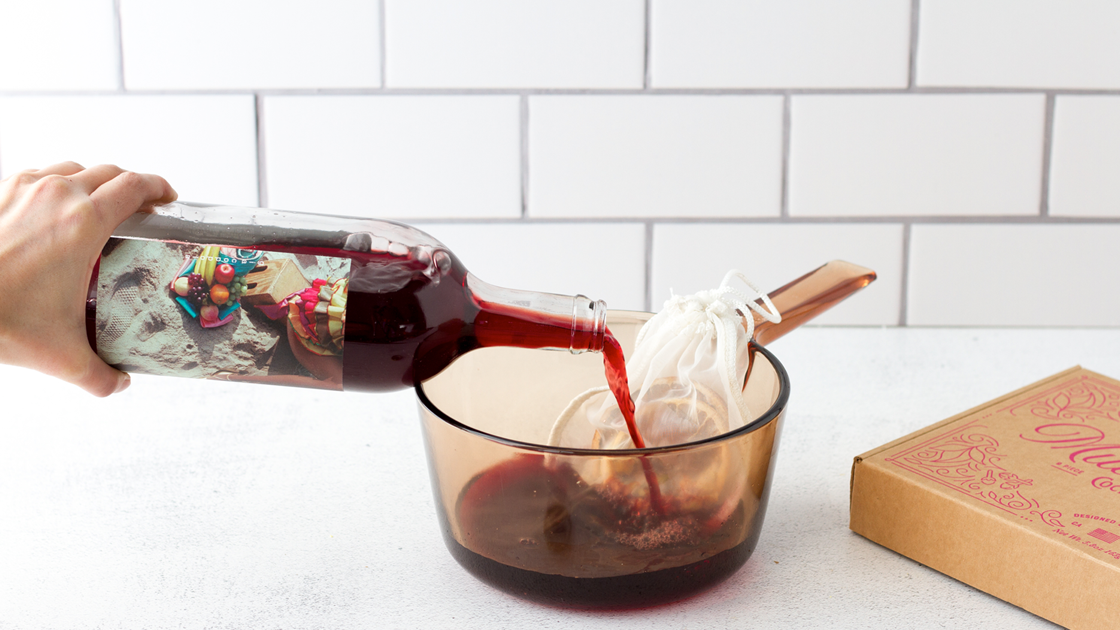 Red wine being pour into a pot with a Mulled wine kit.