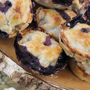 A stack of small blueberry pies.