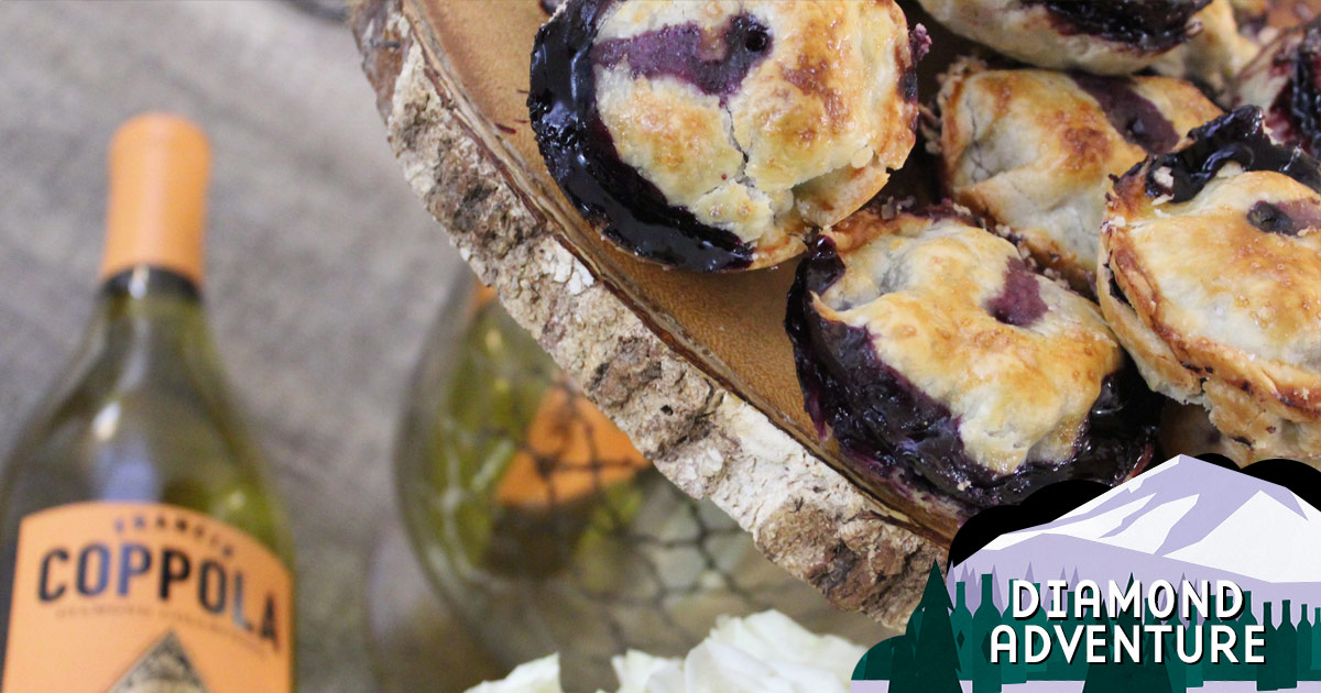 A stack of small blueberry pies and a bottle of Diamond Chardonnay.