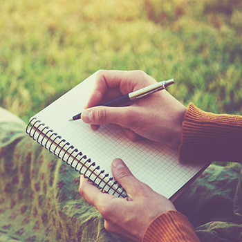 A hand writing in a journal.