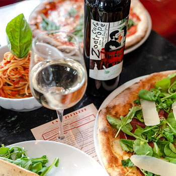 A table filled with many plates of different kinds of food made at Café Zoetrope.
