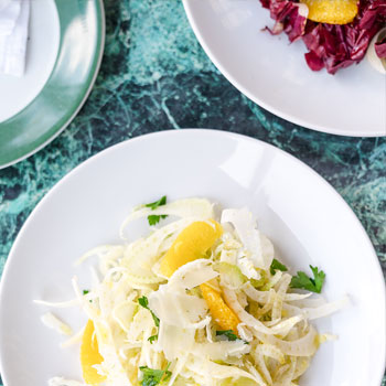 Plated of salad on a green marble table.