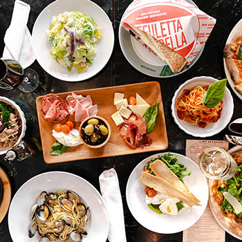 A table filled with many plates of different kinds of food made at Café Zoetrope.